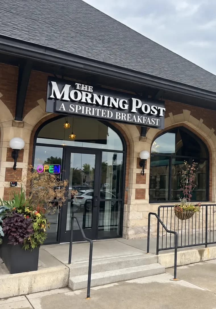 The Morning Post's sign above its entrance in downtown Lansing, with an OPEN neon sign in the window