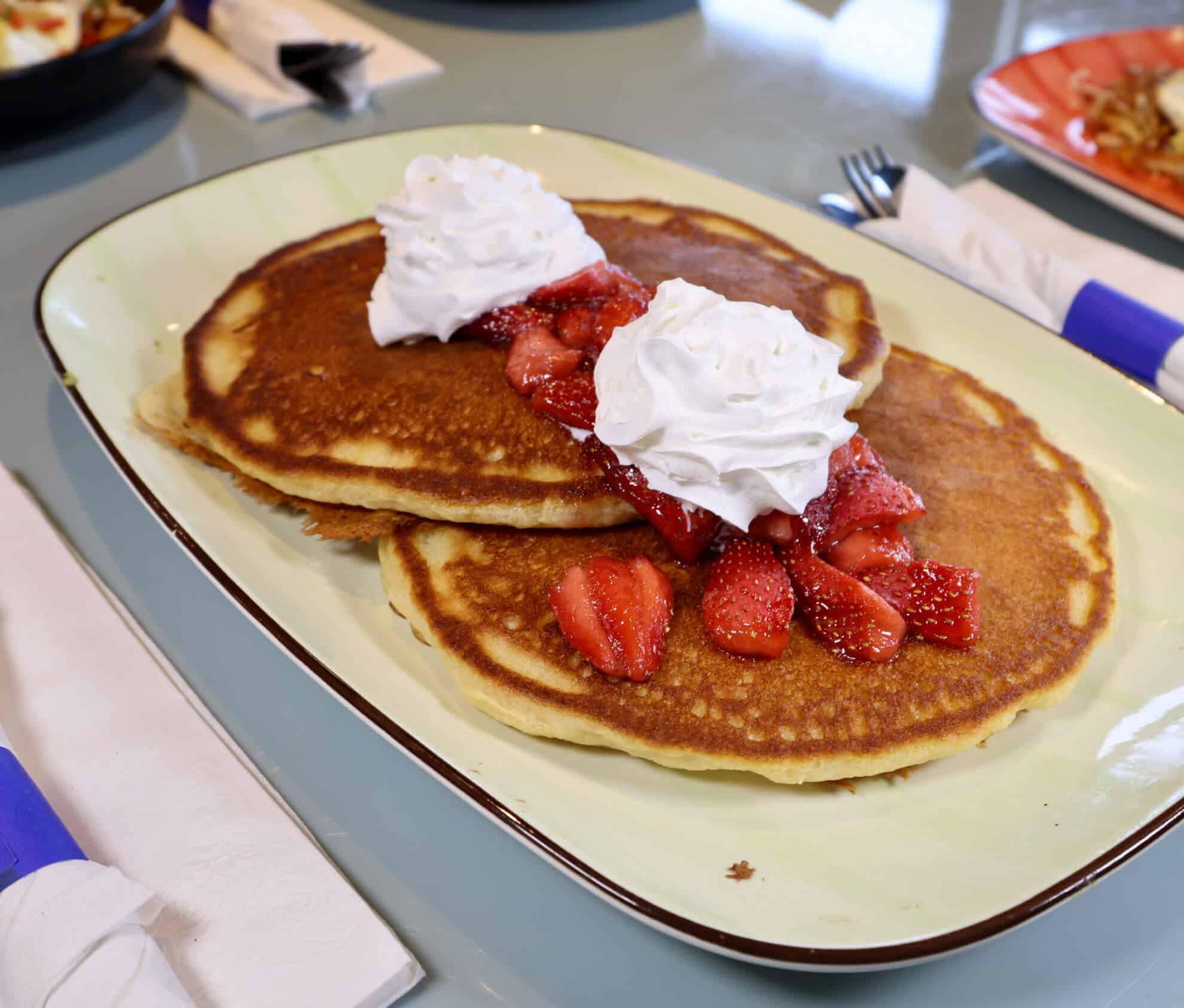 Sweet Cream Pancakes topped with strawberries and whipped cream at The Morning Post
